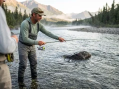 4 Fish Spawning Triggers Most Guides Skip Angler reading water flow and gravel substrate to understand fish spawning triggers.