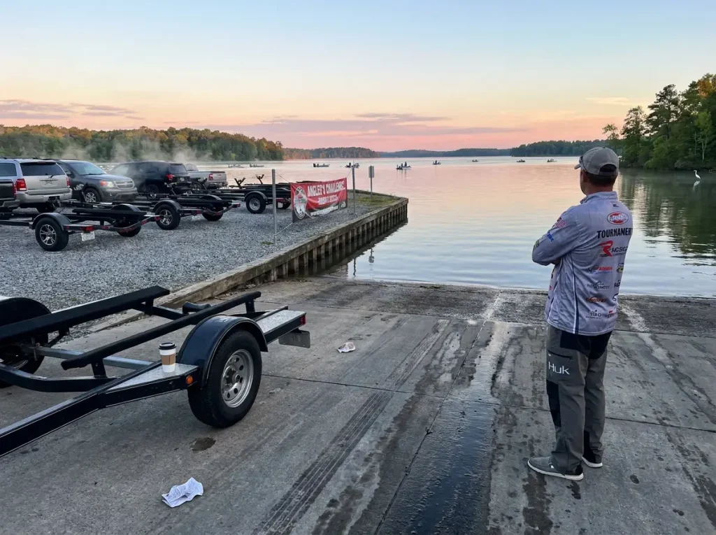 Empty tournament boat launch area at dawn with multiple trailers parked