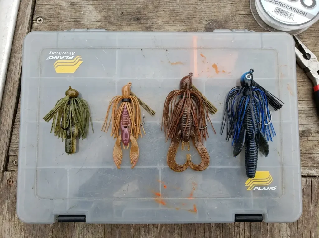 Four football jigs in different weights arranged on a tackle tray from lightest to heaviest