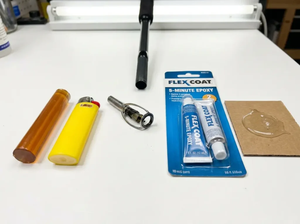 Amber hot melt glue stick next to two-part rod epoxy with fishing rod tip in background