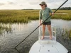 How Red Drum Biology & Habitat Facts Drive Tailing Behavior Angler spotting tailing red drum in shallow Spartina grass