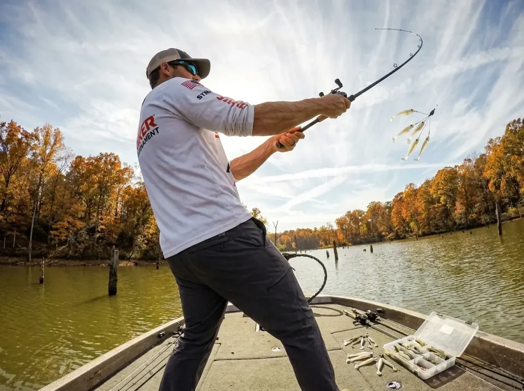 Angler casting an Alabama rig from a bass boat on Lake Guntersville in fall