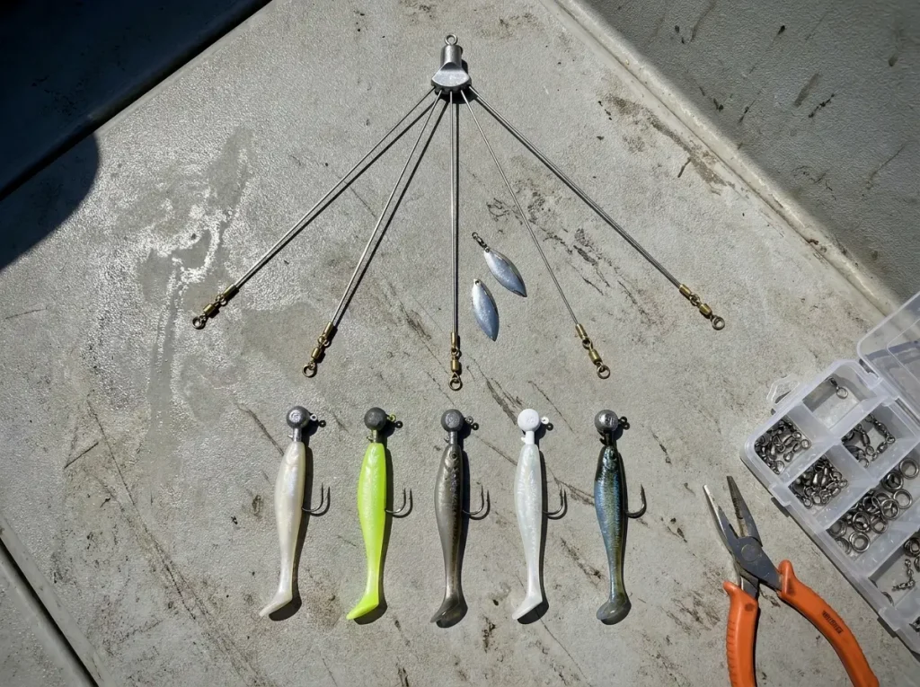 Close-up of Alabama rig components showing wire arms swivels and swimbaits on a boat deck
