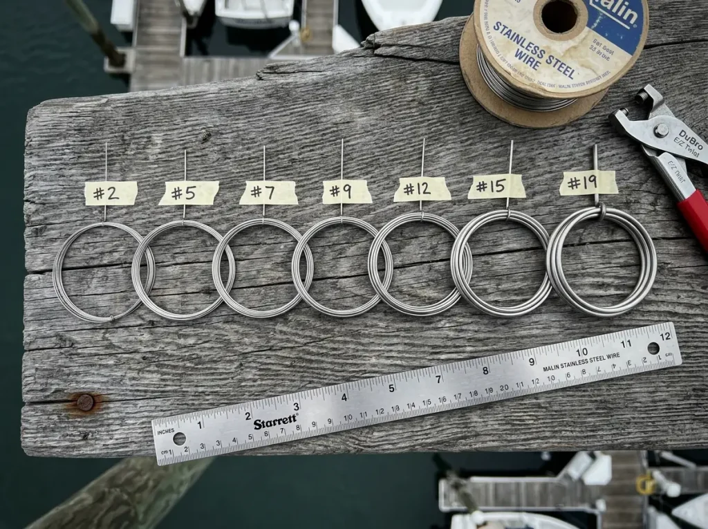 Various fishing wire gauges arranged by size from thin to thick on weathered wood dock