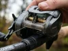 4 Level Wind Mistakes That Shorten Reel Life Baitcaster level wind mechanism close-up showing worm gear and line guide on rod