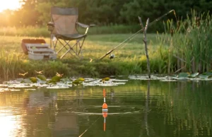 How to Fish a Slip Bobber for Panfish Step by Step Slip bobber floating on calm lake with line angled down toward panfish