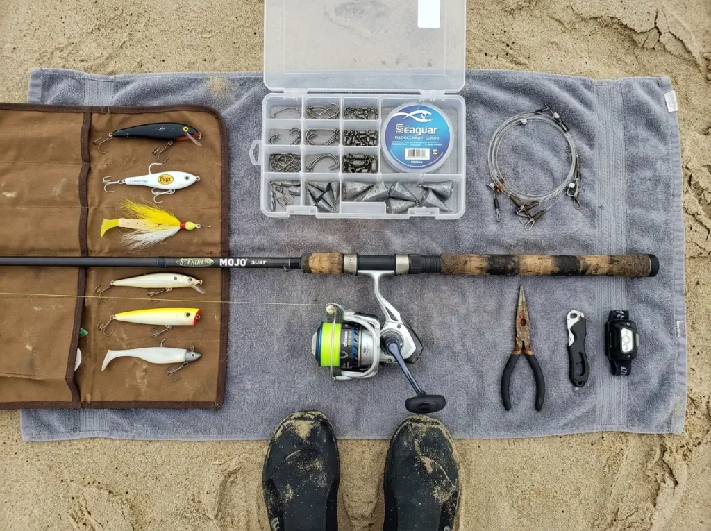 Surf fishing tackle spread on beach showing rod reel braid and leader setup