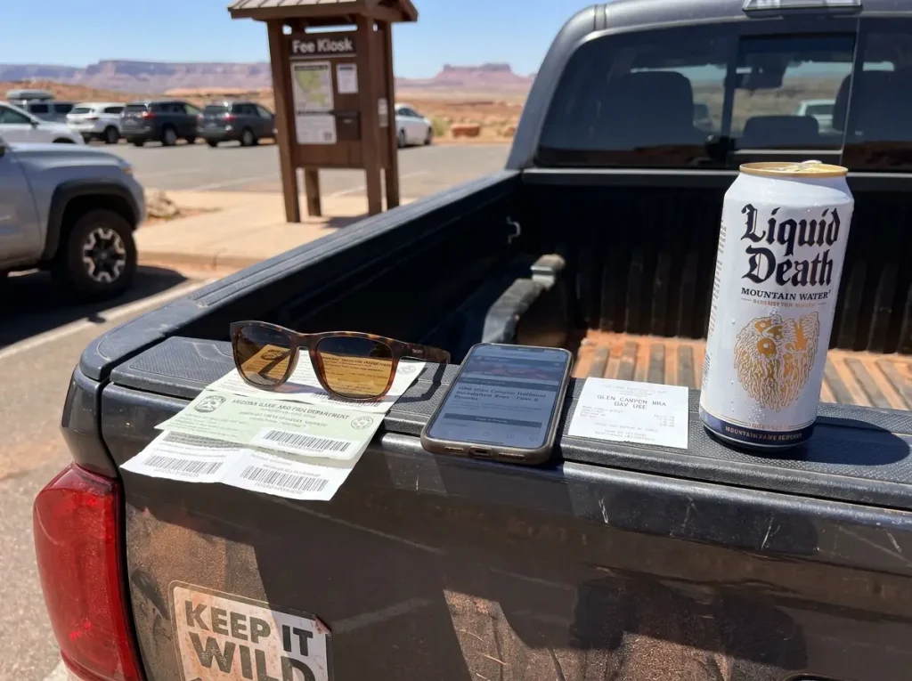 Utah and Arizona fishing licenses laid on a truck tailgate beside Lake Powell tackle