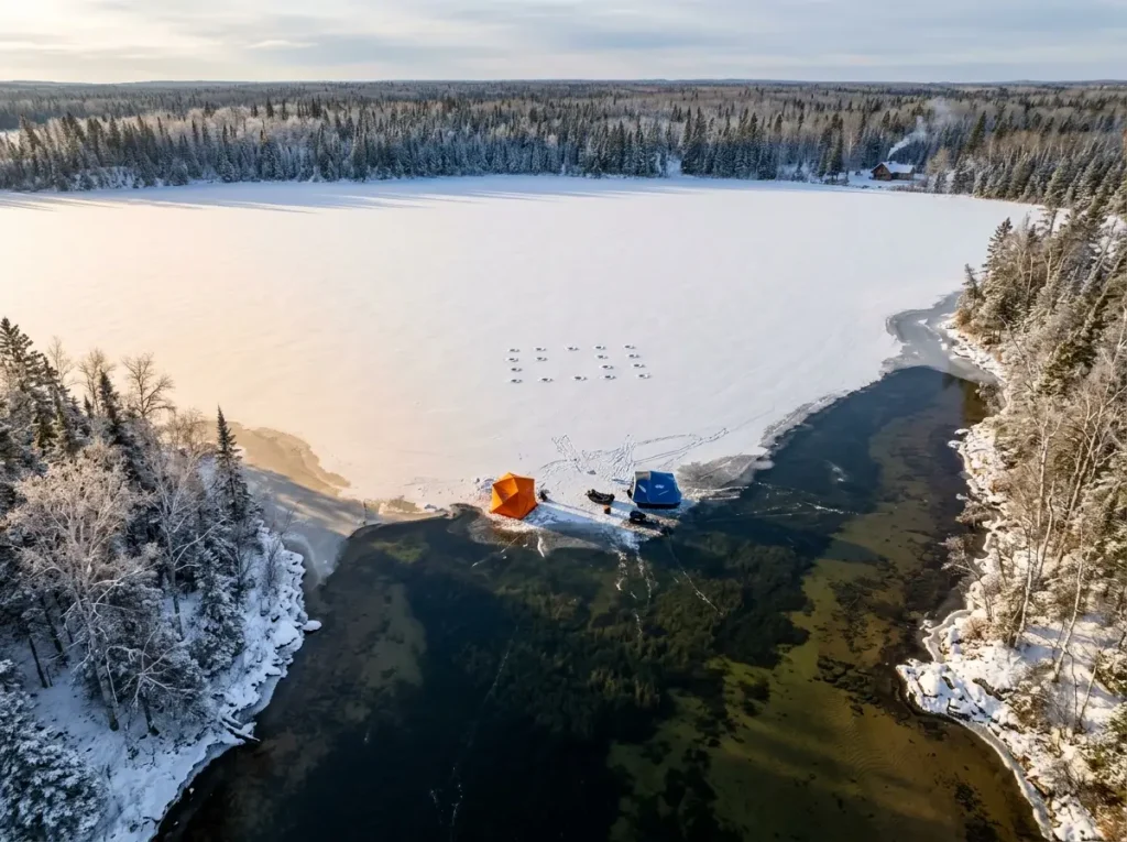 Aerial view of an ice-covered lake showing shallow weeds and deep basin transition
