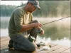 Best Fishing Line for Spinning Reels Without Wind Knots Angler on a lake at dawn holding a spinning reel freshly spooled with braided fishing line