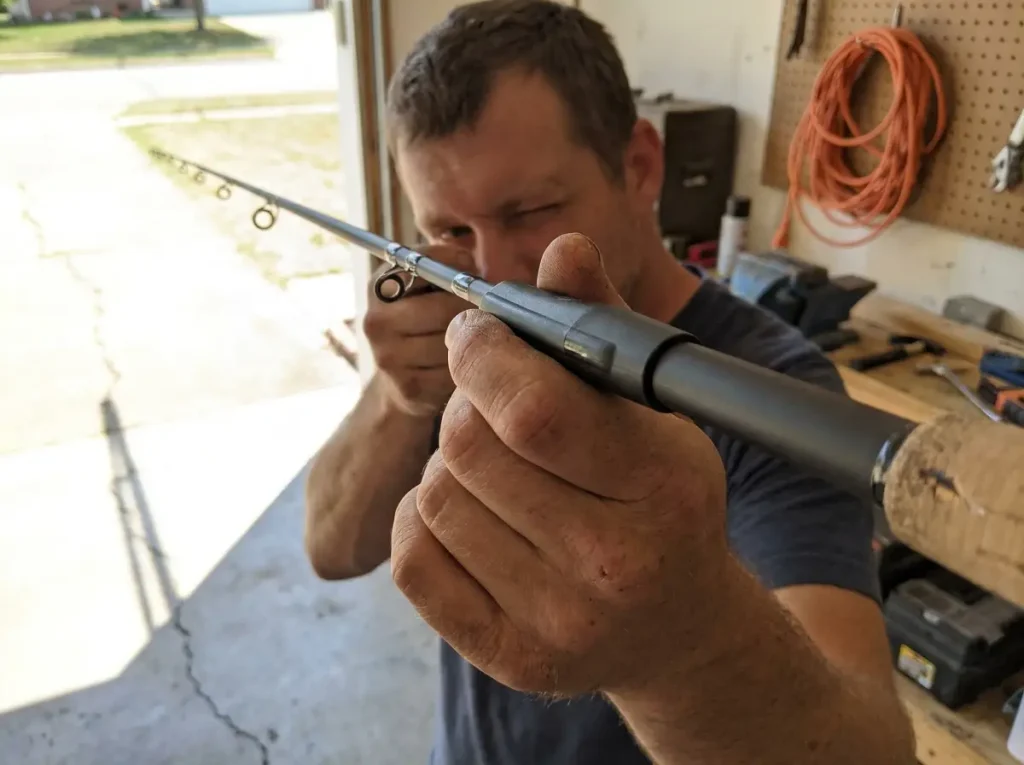 Hands joining two fishing rod sections and aligning the guides in a row