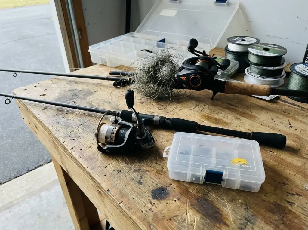 Simple spinning combo and small tackle box beside an unnecessary baitcaster and gear pile