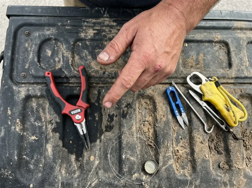 Angler comparing a single multi-function plier against a handful of separate fishing tools on a tailgate