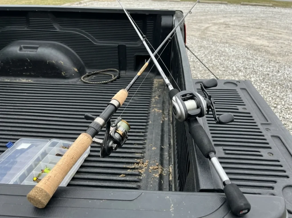 Two fishing rods, a spinning rod and a baitcaster, leaned together in a truck bed as a starter setup