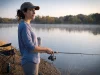 Best Fishing Rods for Beginners Who Just Want to Fish Beginner angler holding an Ugly Stik Elite spinning combo on a lake bank at first light