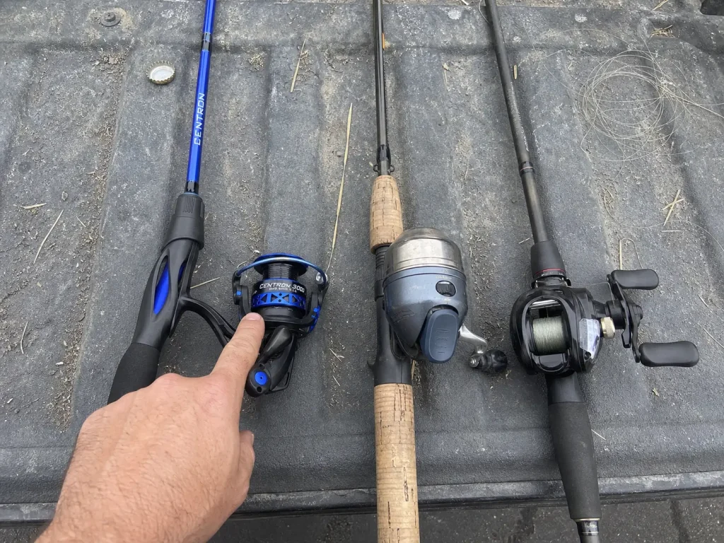 Spinning, spincast and baitcasting setups laid side by side on a truck tailgate