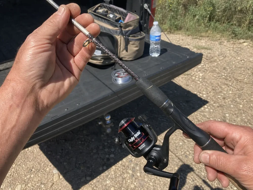 Close-up of a composite spinning rod blank and clear tip held up in bright sun