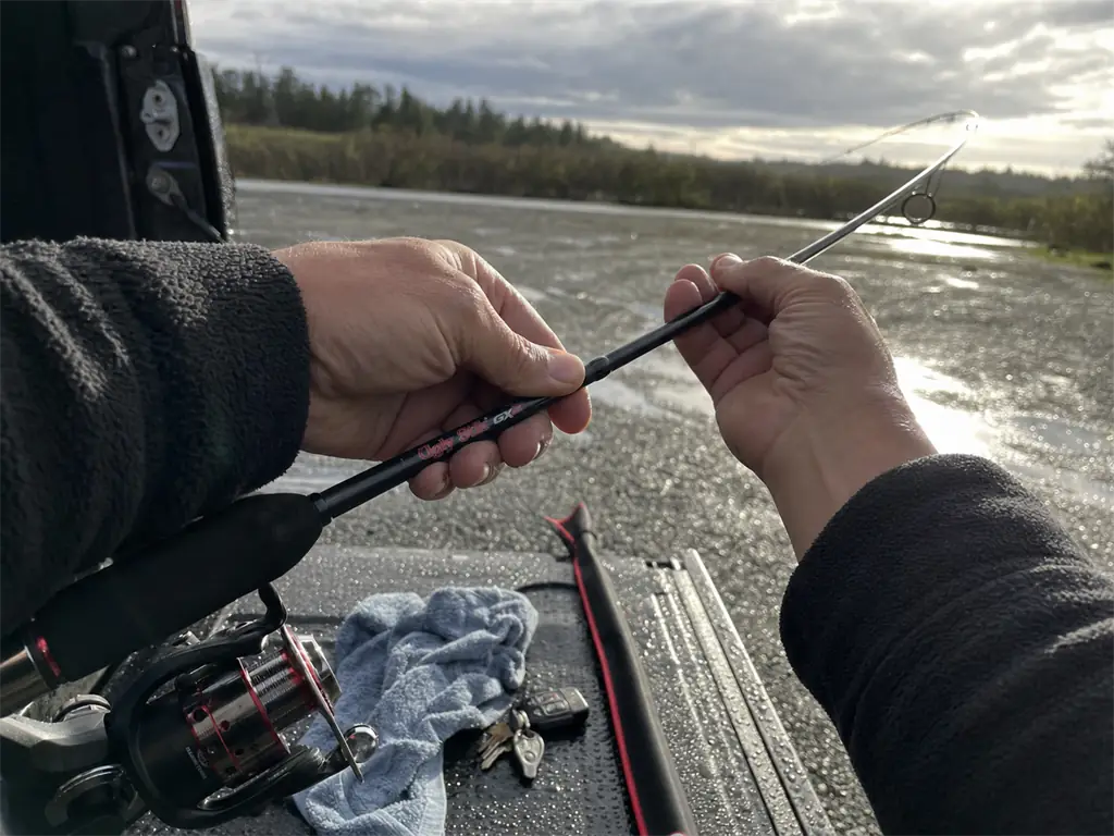 Hands flexing a composite fishing rod blank to feel how the material bends