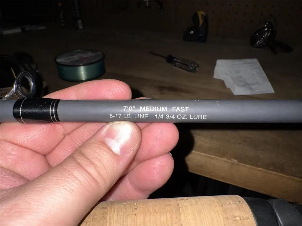 Close-up of the line and lure weight ratings printed on a fishing rod blank above the handle