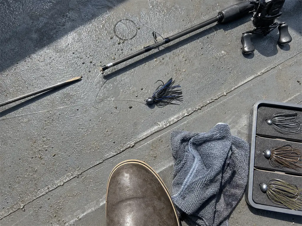 A snapped rod tip and heavy jig on a boat deck after casting past the rod's lure rating